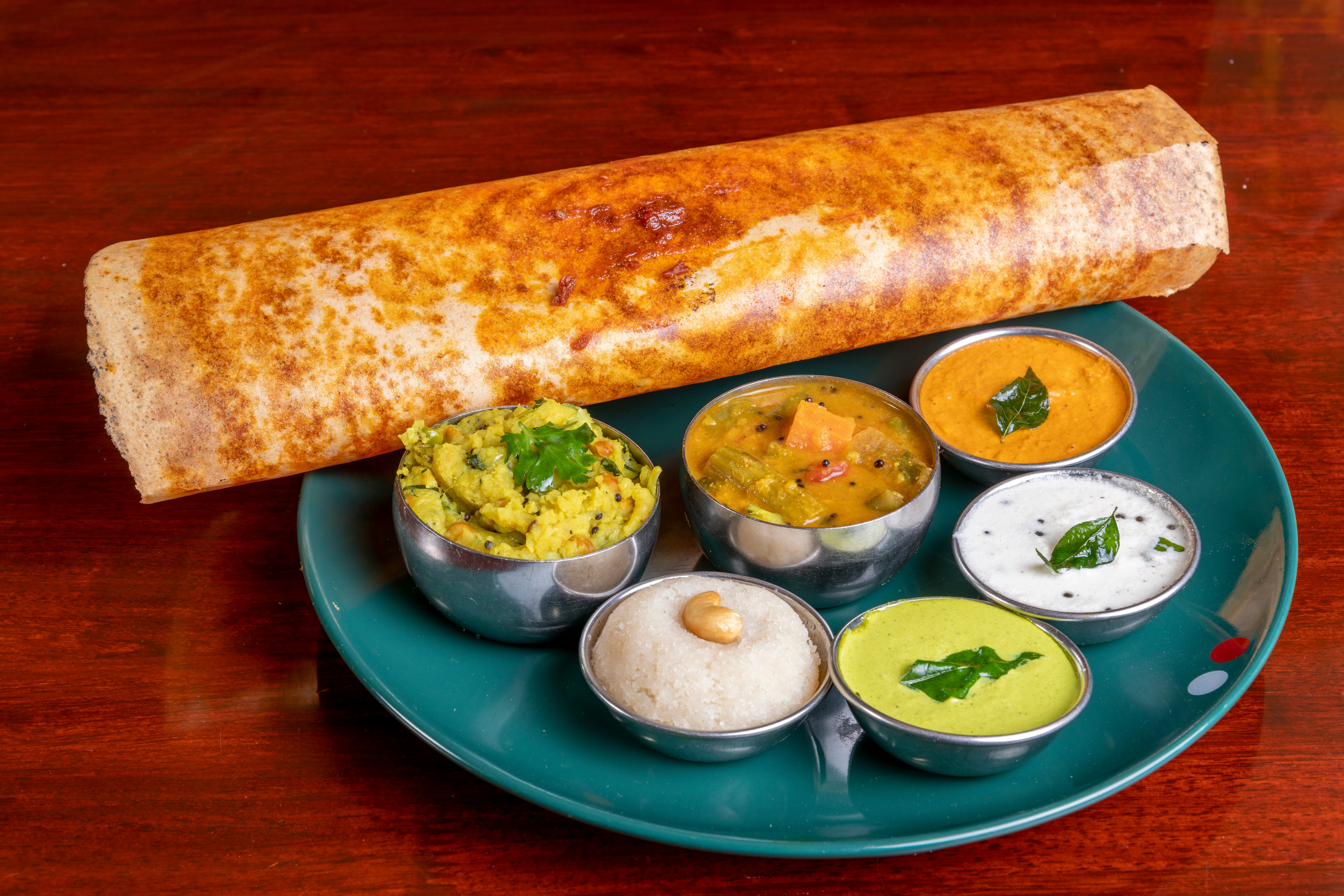 A golden masala dosa with chutneys