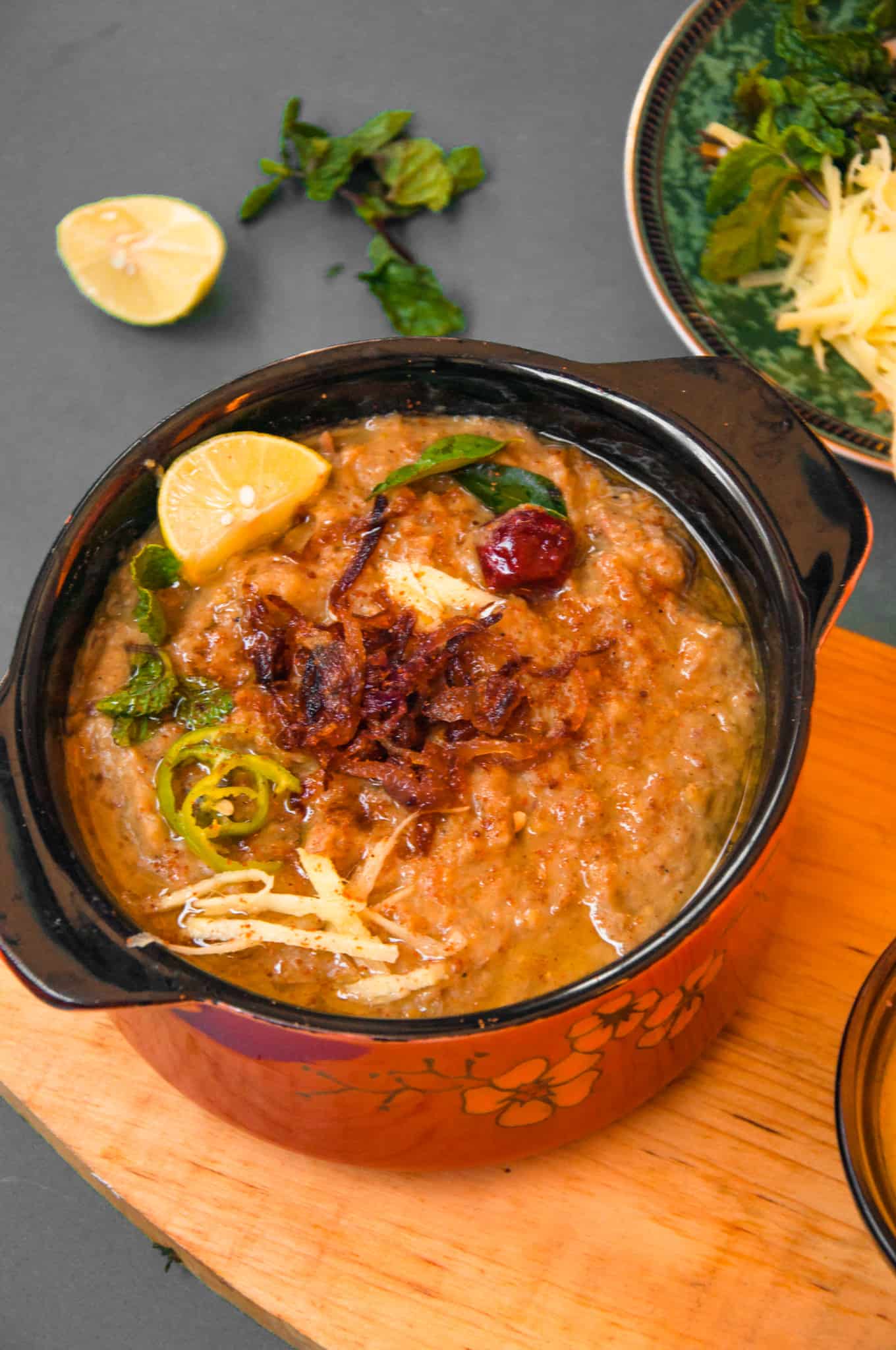 A bowl of haleem topped with fried onion
